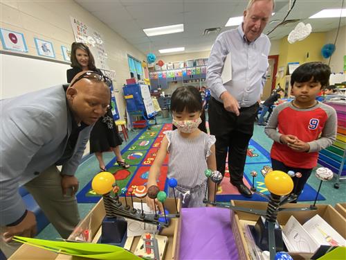 Assistant Superintendent Eric Terrell and Senator Tom Butler with students showing their models of planets